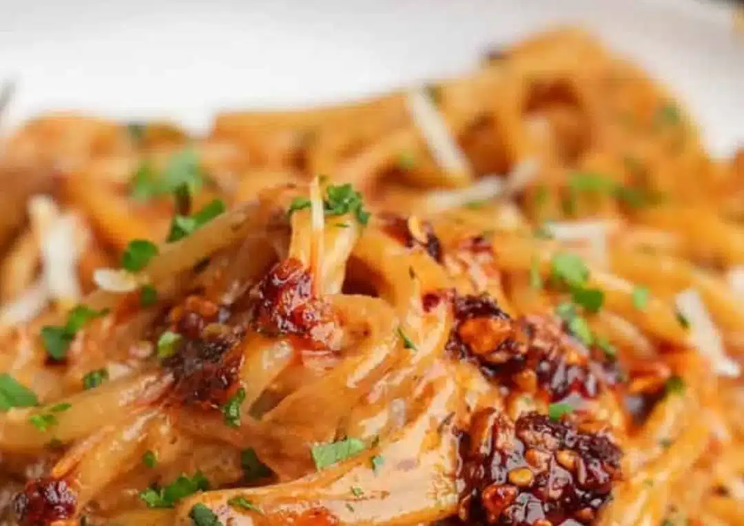 Delicious caramelized onion pasta topped with chili oil for extra flavor