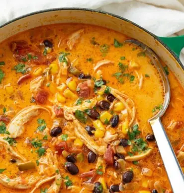 Bowl of hearty Chicken Enchilada Soup topped with cheese and cilantro