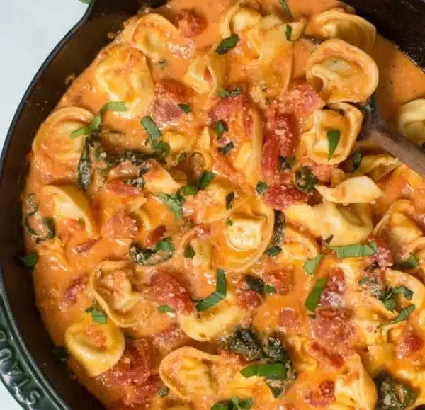 Creamy Tomato Basil Tortellini Skillet dish garnished with fresh basil